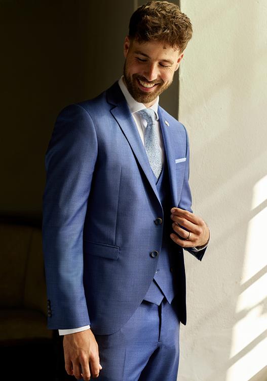 Bruidegom past een trouwpak met stylingadvies in de winkel