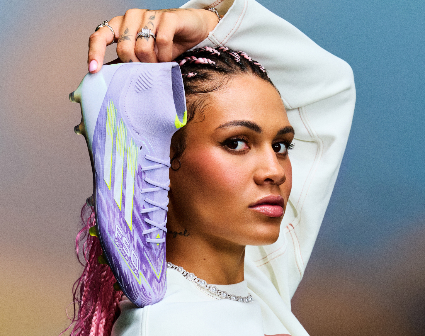 Vrouw houdt paarse voetbalschoen naast haar hoofd
