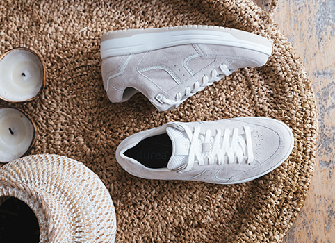 Paar lichte sneakers op een lichte ondergrond