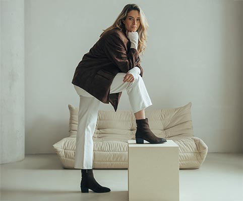 dame met opgetrokken knie en bruine laarsjes