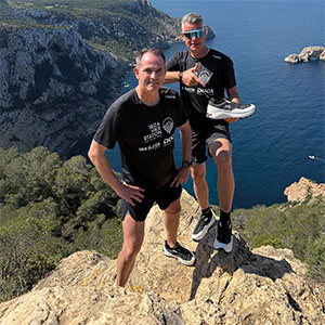 Mannen op rots met Duca schoen in hand