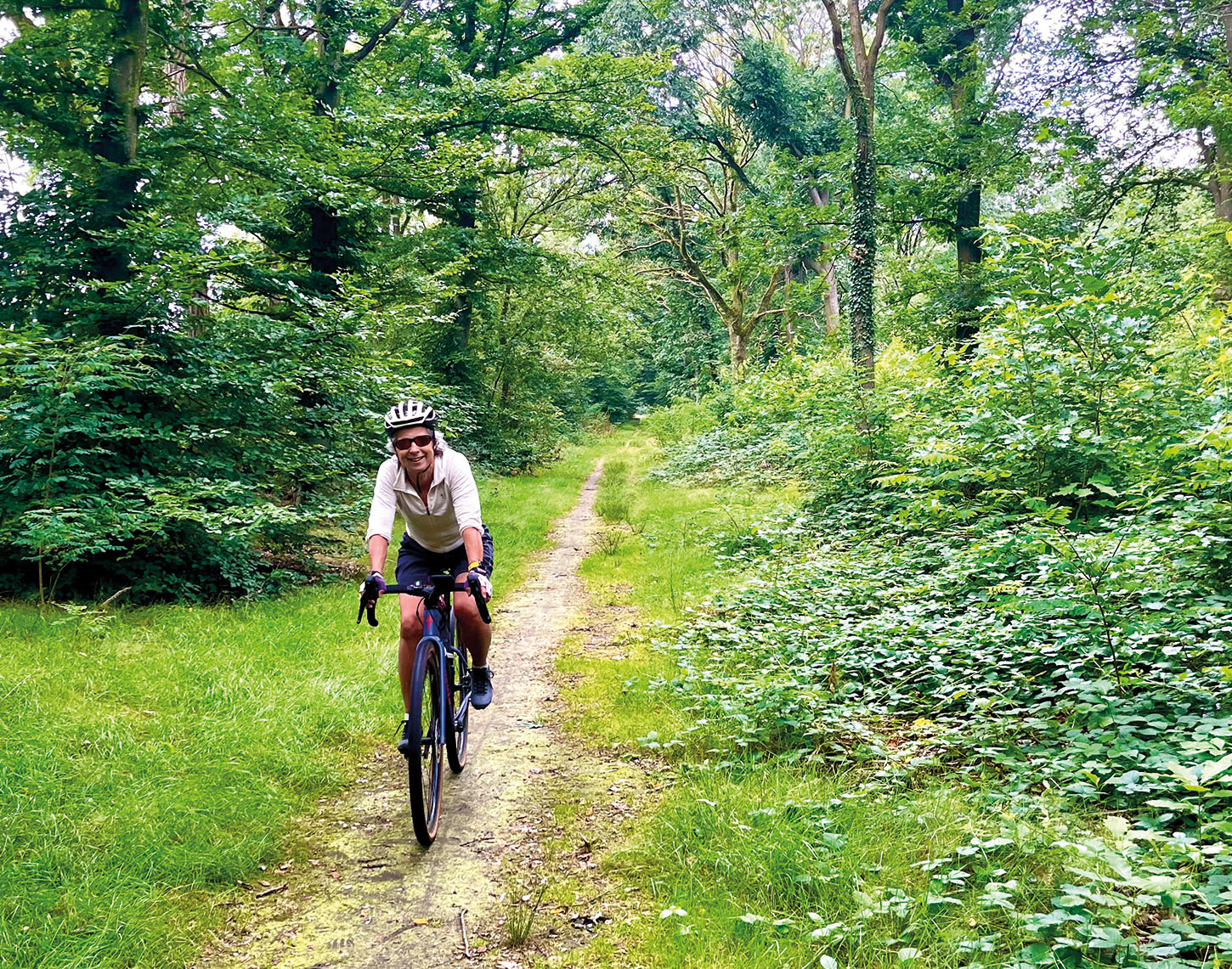 vrouw op fiets op een bospaadje