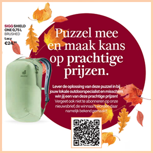 vrouw en 2 honden voor een camper in de sneeuw