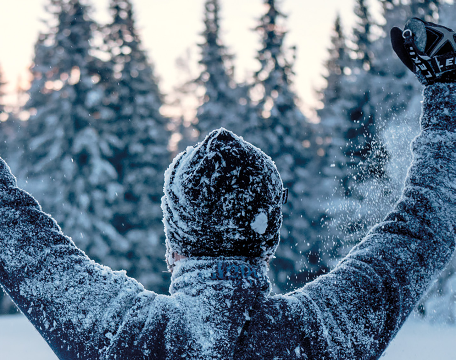 juichgende man op de rug gezien, staand in de sneeuw