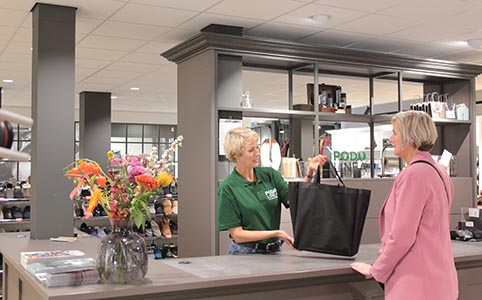 dame die afrekent bij de kassa in een schoenenwinkel