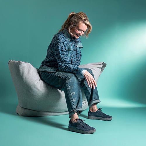 dame met donkere kleding en donkere veterschoenen op zitzak