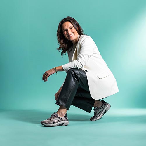 dame gehurkt met paars tint metallic sneakers