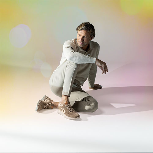 Man zit nonchalant op de vloer met Gijs sneakers