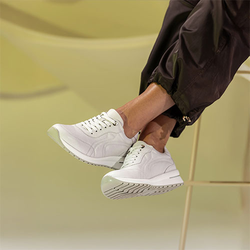 dame op kruk met benen over elkaar