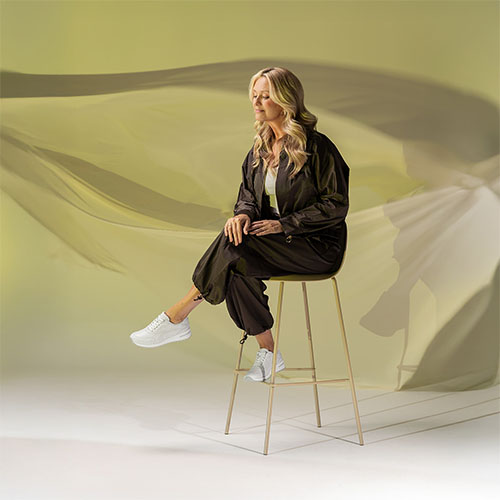 dame op kruk met knieen over elkaar