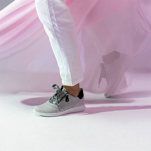 Damesbeen met Hartjes sneakers en roze achtergrond