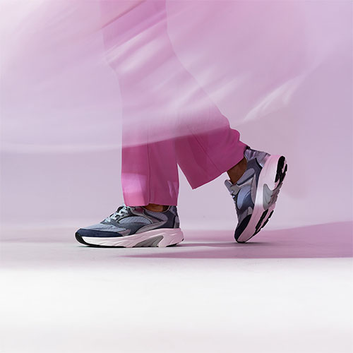 Damesbenen met Gabor sneakers en roze broek aan het lopen