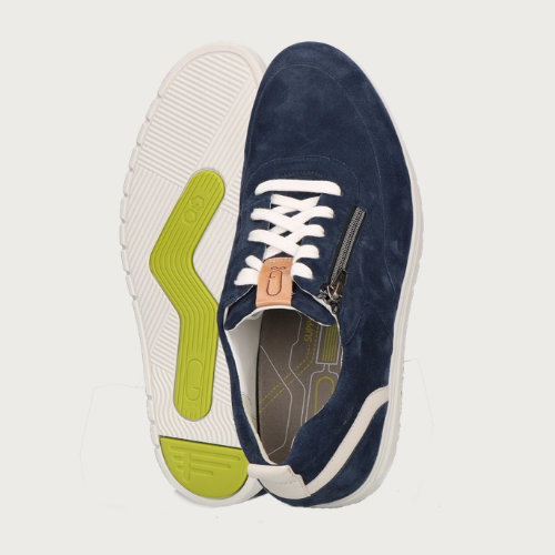 man geknield voor groene achtergrond met bruine sneakers