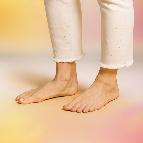 1 paar benen met blote voeten op oranje achtergrond