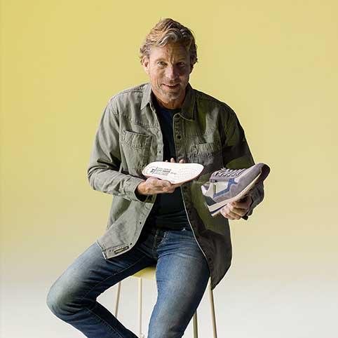 dame die bruine sneaker vasthoudt